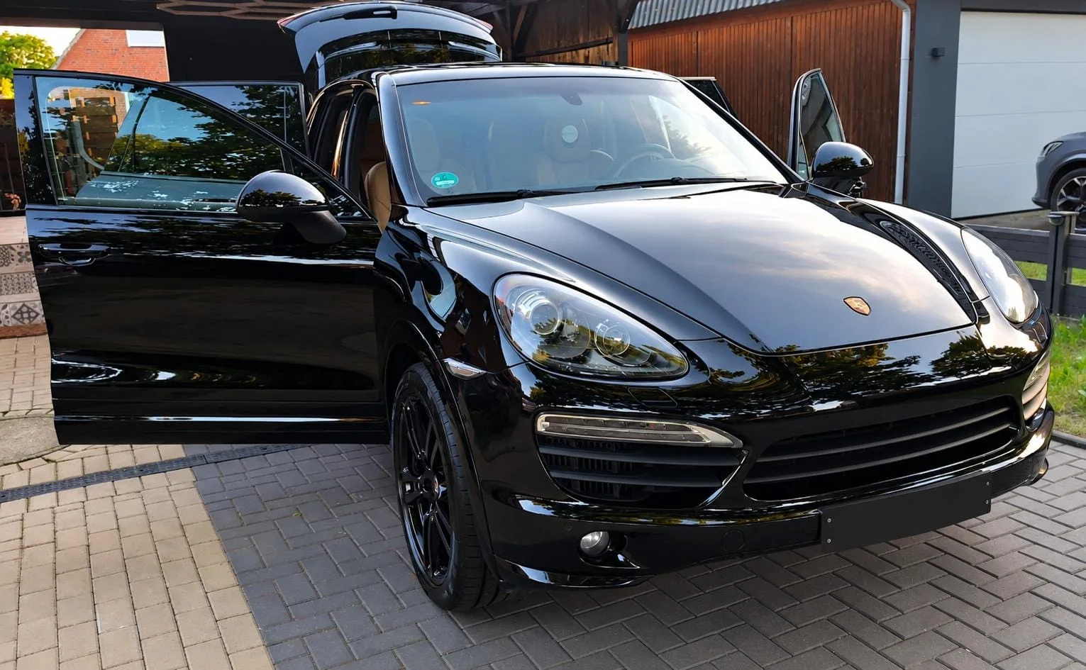 Frisch aufbereiteter schwarzer Porsche Cayenne mit geöffneten Türen